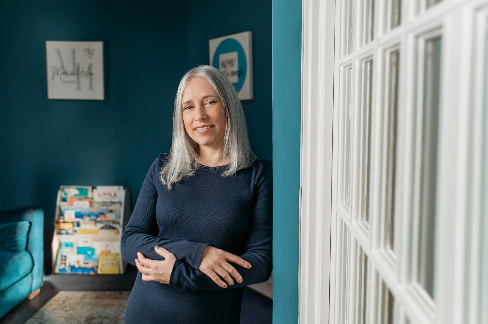Marie leaning in the doorway of her teal coaching room